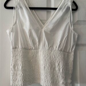White Sleeveless Top. Deep V front & back. Smocked bottom Faux ties at shoulder